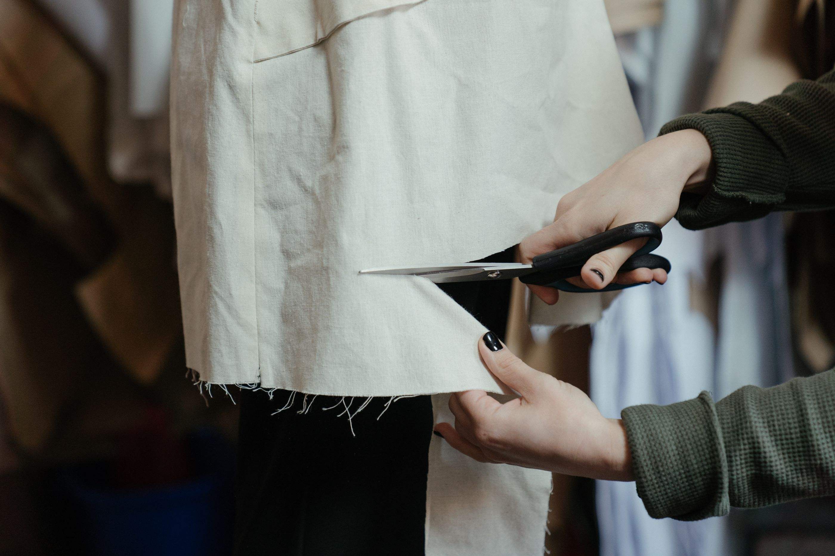 Trimming a muslin mock-up on a dress form with dressmaker shears