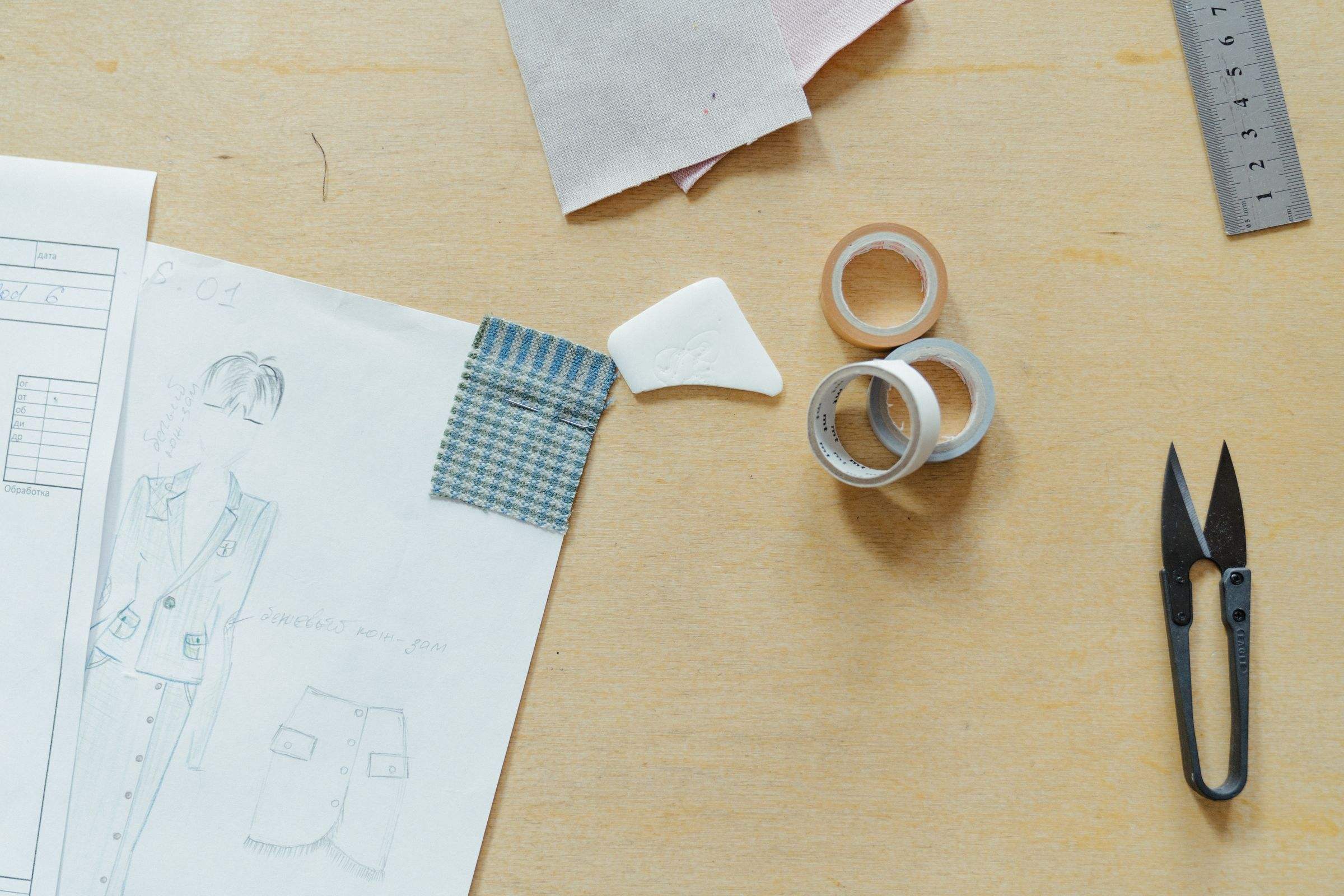 Sketches, fabric samples, tape and snips on a design desk