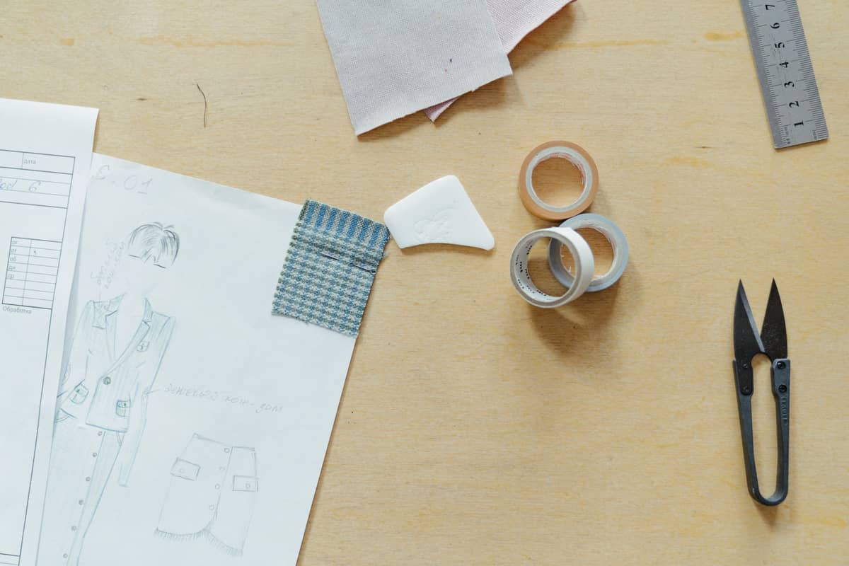 Sketches, fabric samples, tape and snips on a design desk