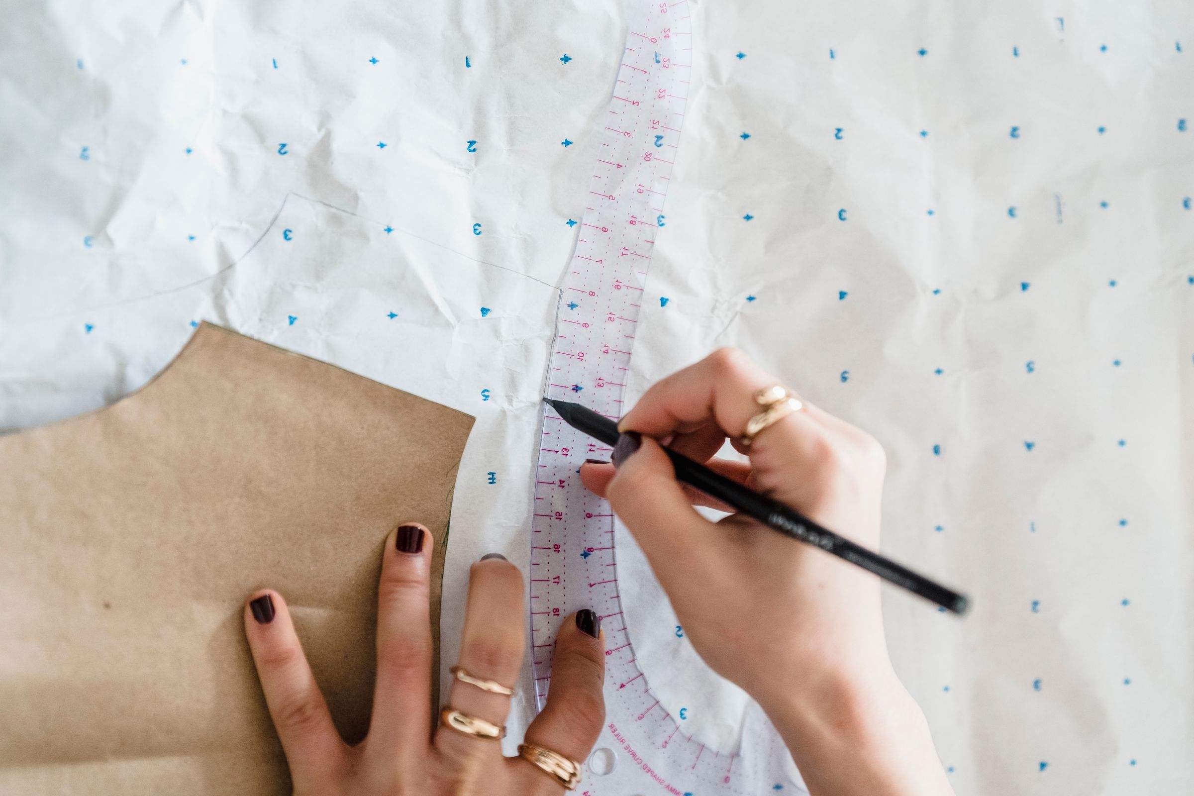 Tracing a neckline with a French curve on pattern paper