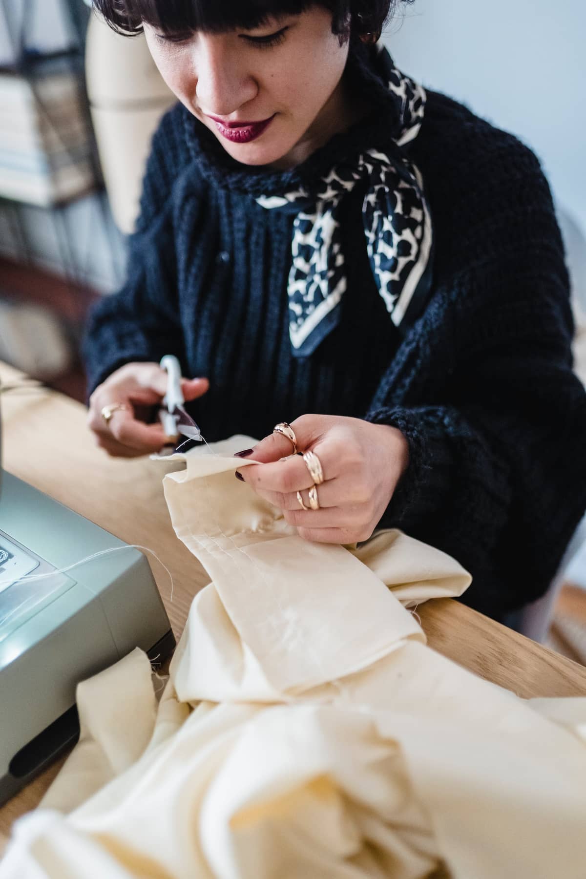 A seamstress hand-finishing a muslin garment