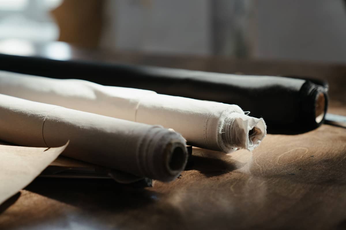 Rolls of muslin and canvas on a wooden bench
