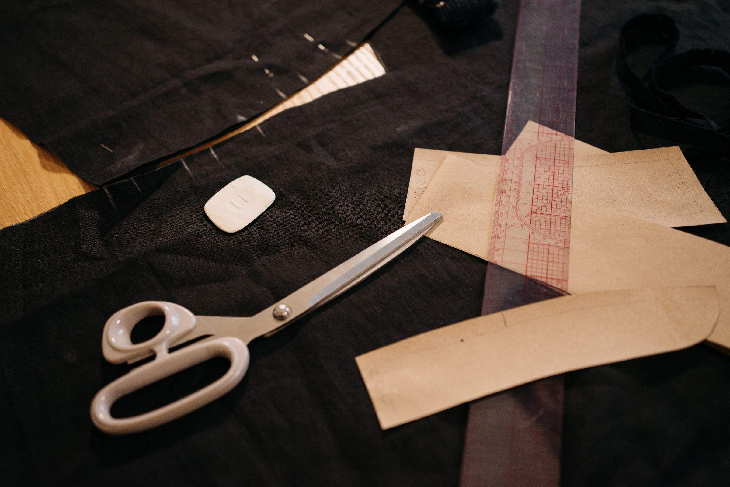 Shears and kraft pattern pieces on black fabric