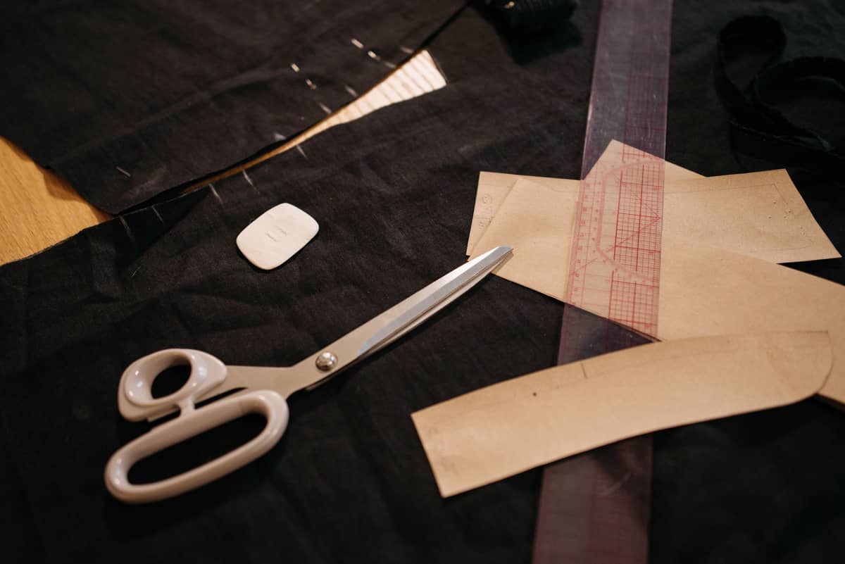 Shears and kraft pattern pieces on black fabric