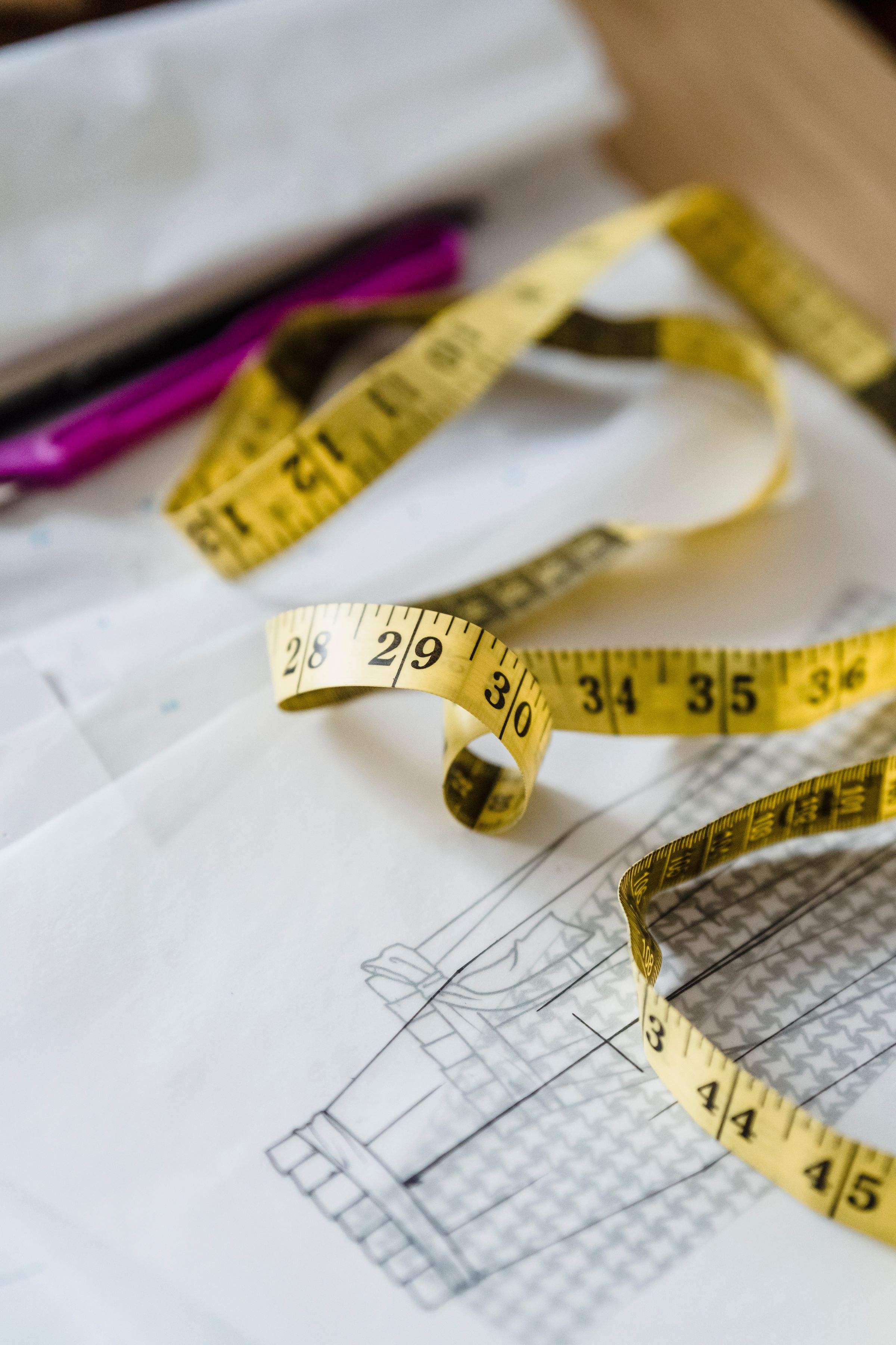 A yellow tape measure over a drafted pattern